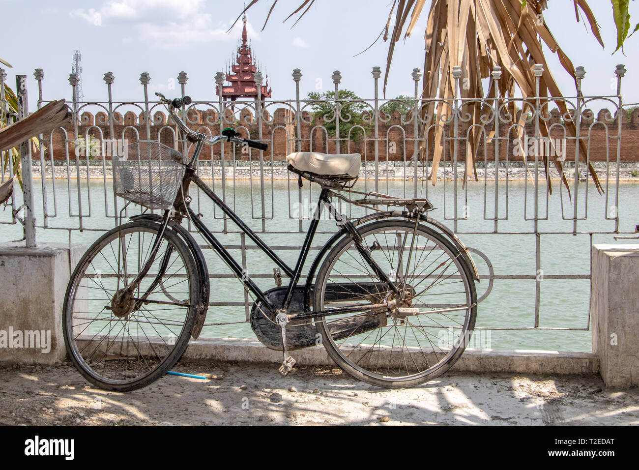 An old bicycle is lean on a railing over a water moat before the Royal