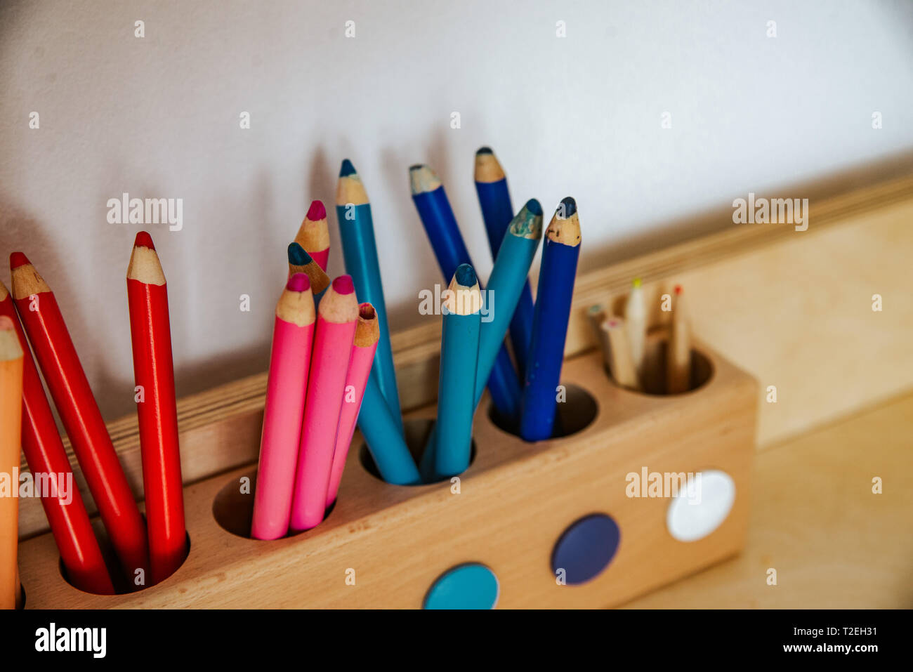 colored pencils in a container on a wooden table, close up on blue Stock Photo