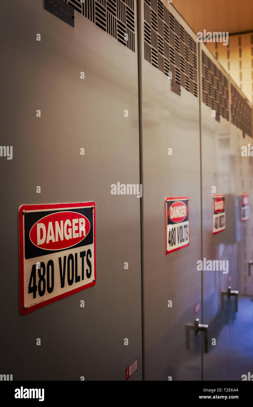 High Voltage Danger signs line the electrical cabinets of the George W. Kuhn wastewater treatment plant in Madison Heights, Michigan, USA Stock Photo