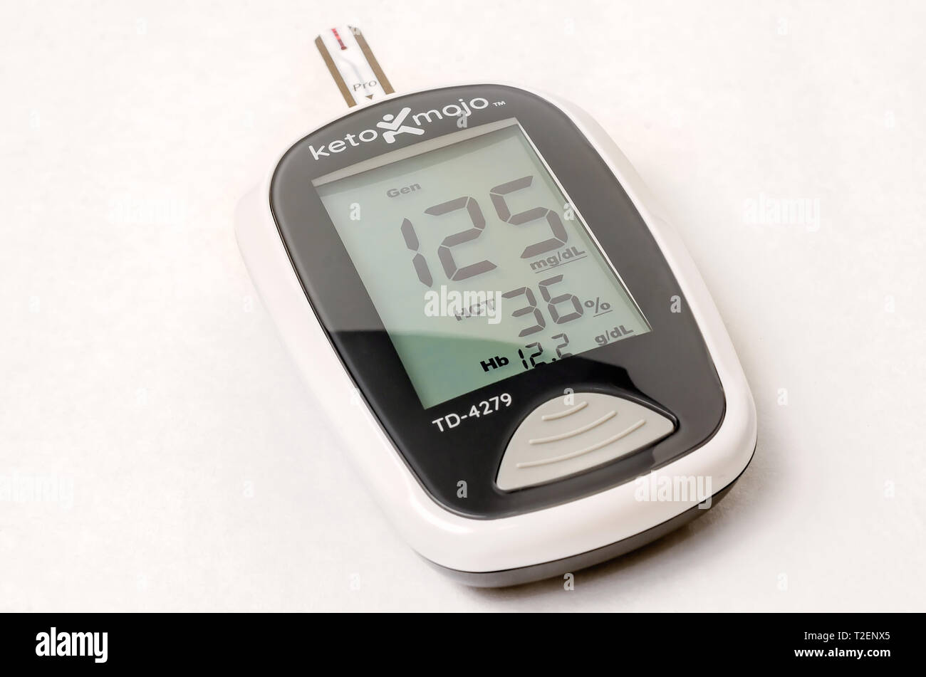 A Keto-Mojo ketone and blood glucose meter is pictured on white, along with a blood glucose test strip, March 30, 2019, in Coden, Alabama. Stock Photo