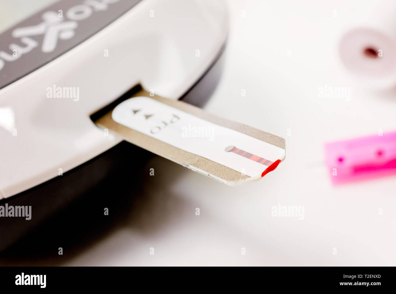 A Keto-Mojo ketone and blood glucose meter is pictured on white, along with a blood glucose test strip, March 30, 2019, in Coden, Alabama. Stock Photo