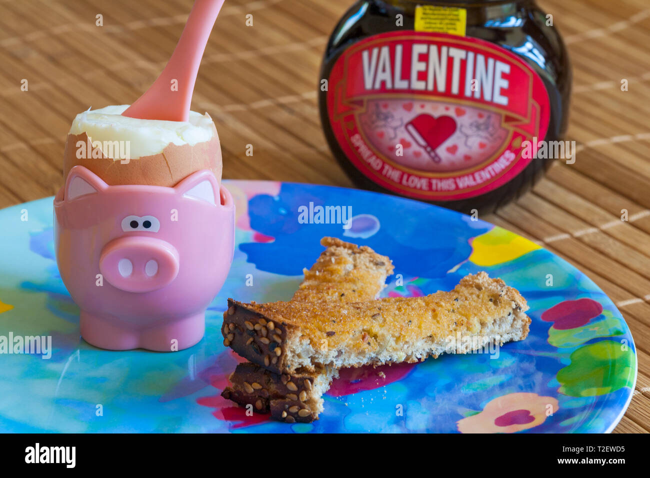 Boiled egg in egg cup with soldiers toast and jar Special edition jar of Valentine Marmite by Unilever - breakfast concept Stock Photo