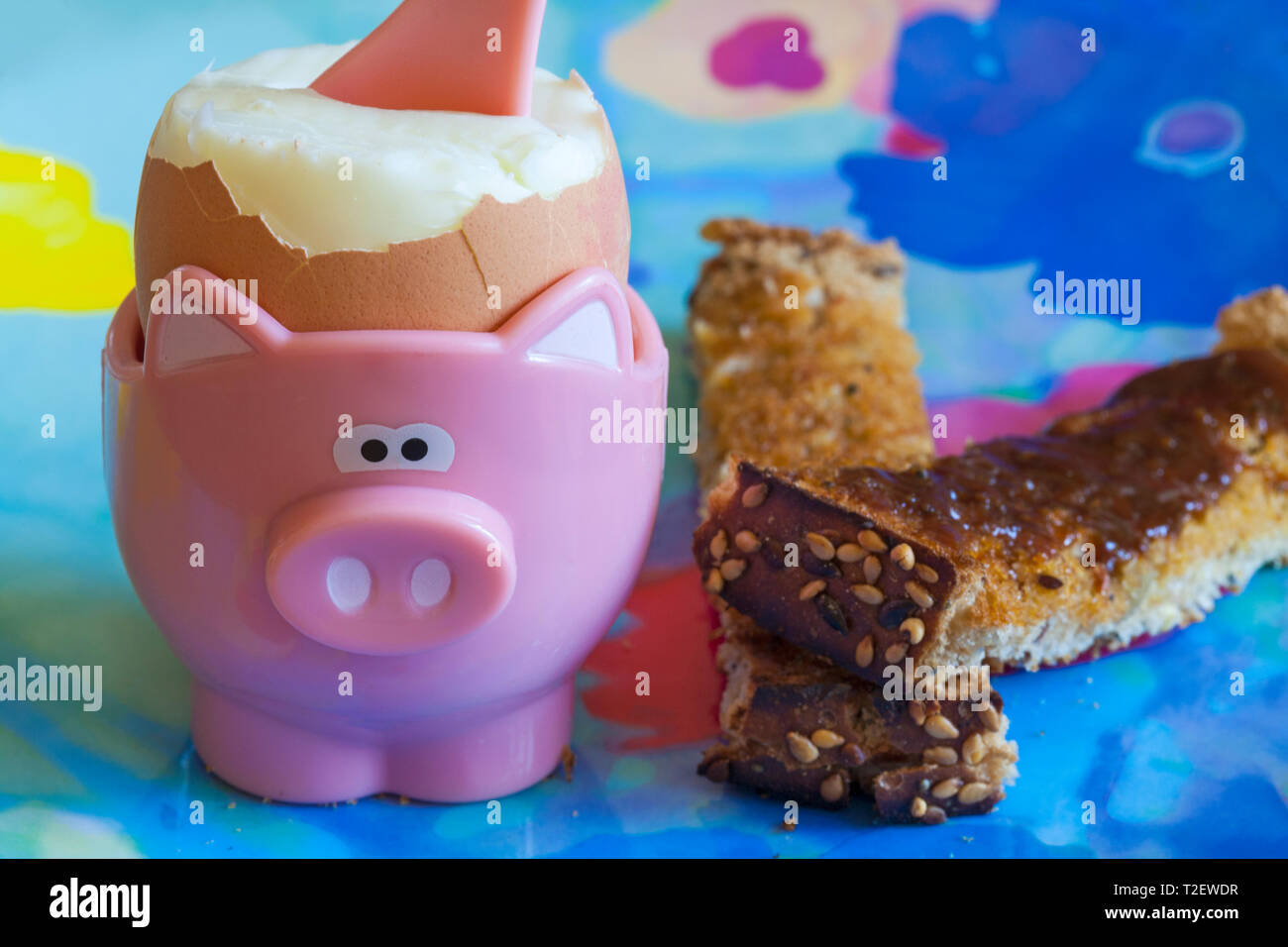 Boiled egg in egg cup with marmite on soldiers toast breakfast
