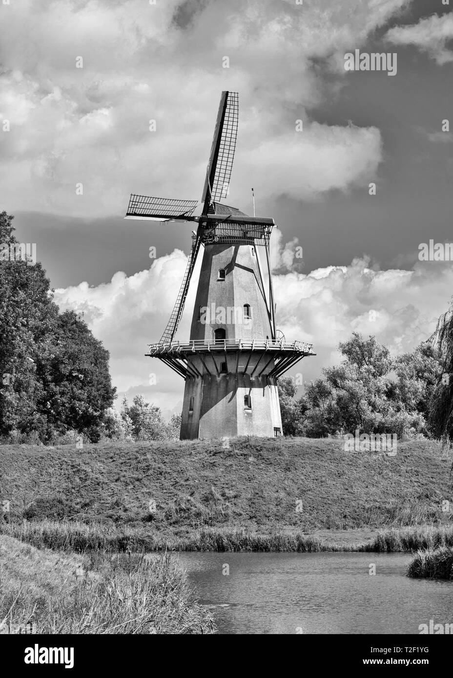 Ancient floor mill build on a city wall with dramatic clouds, The Netherlands Stock Photo
