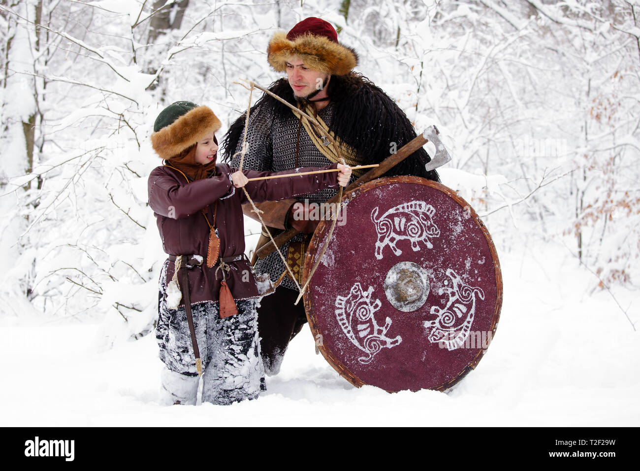 Viking warrior with chain mail leather spear walking in winter woods