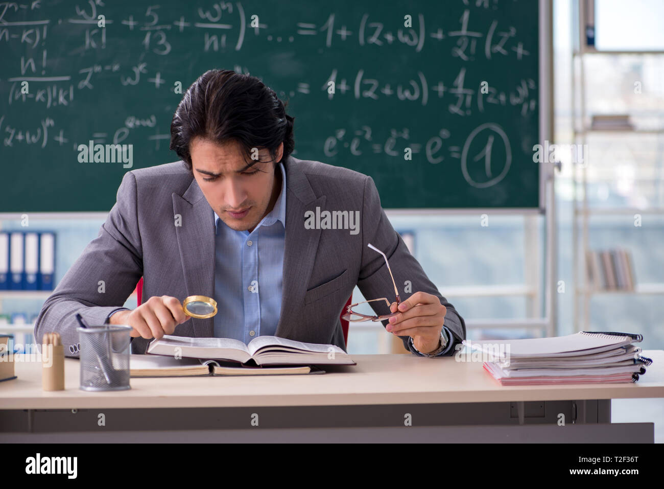 Young handsome math teacher in classroom Stock Photo
