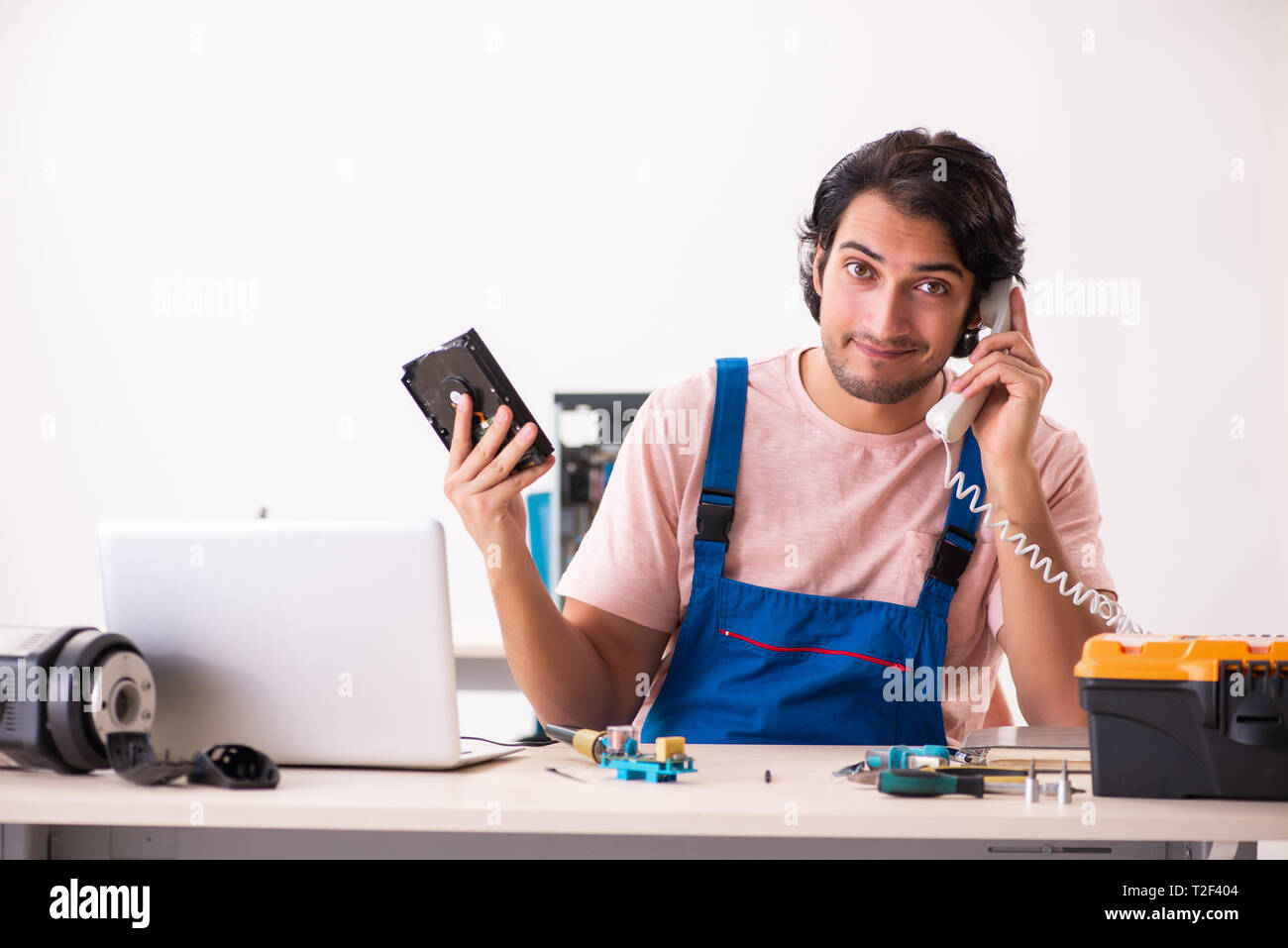 Young male contractor repairing computer Stock Photo