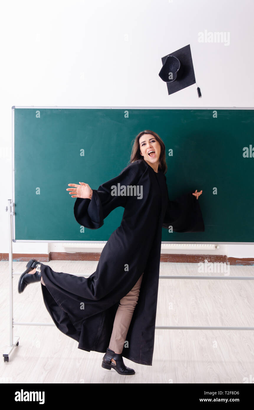 Female graduate student in front of green board Stock Photo - Alamy