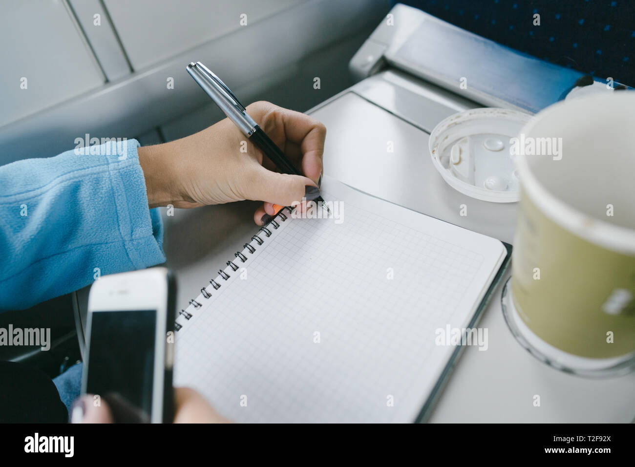 Women working while riding in a train. Women hands writing in a ...