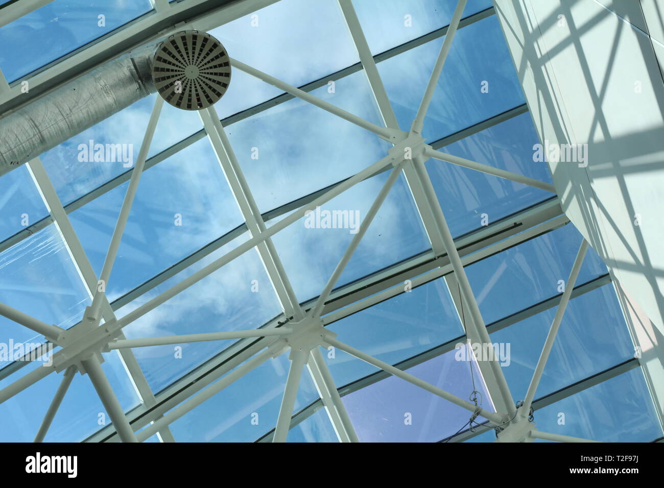 Glass roof in the business center. Metal and glass construction - architecture and design in a shopping center. Stock Photo