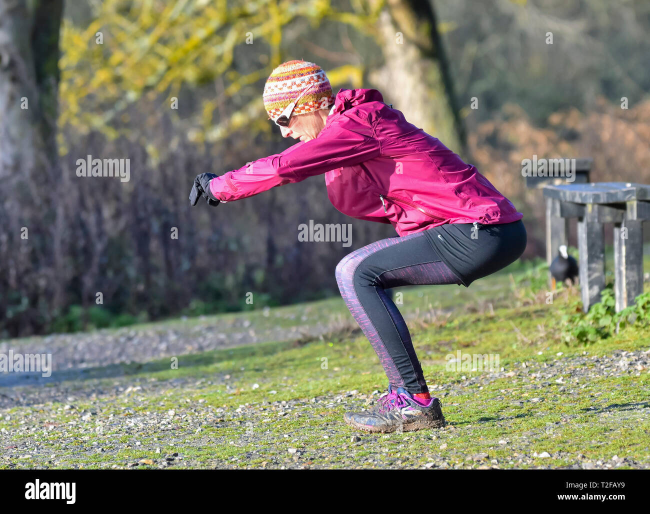 Middle aged woman outside in Winter, stretching and exercising. Stock Photo
