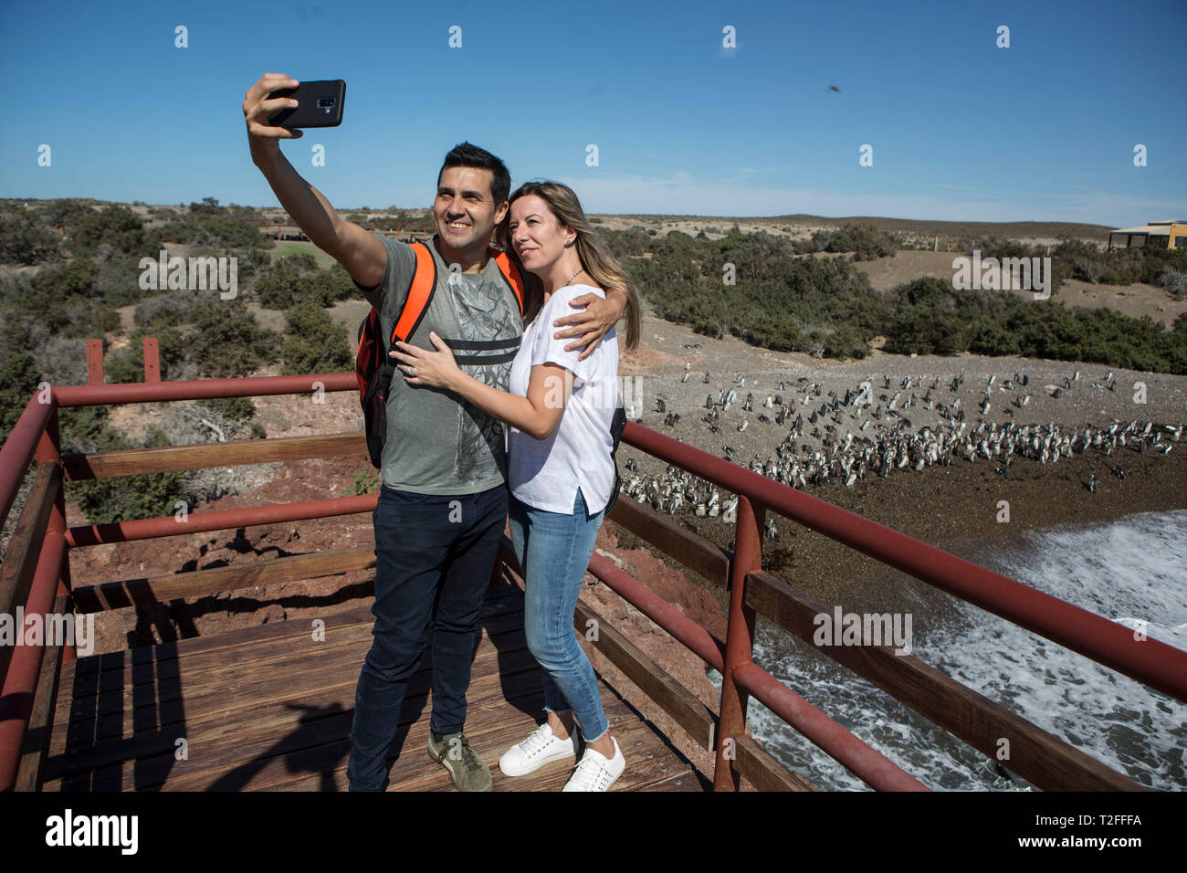 Chubut. 28th Mar, 2019. Photo taken on March 28, 2019 shows a couple taking selfies at the Punta Tombo Reserve, Chubut province, Argentina. The reserve was set up in 1979 in order to protect the largest continental colony of Magellanic penguins. Credit: Martin Zabala/Xinhua/Alamy Live News Stock Photo