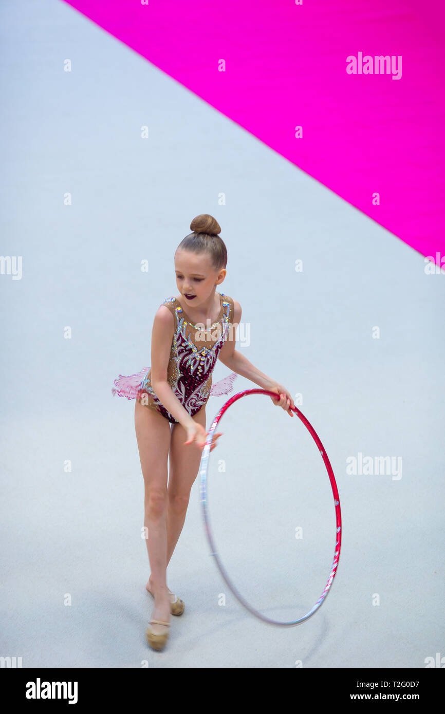 Little girl doing gymnastics with hoop, ball and split isolated on grey  background, studio Stock Photo - Alamy