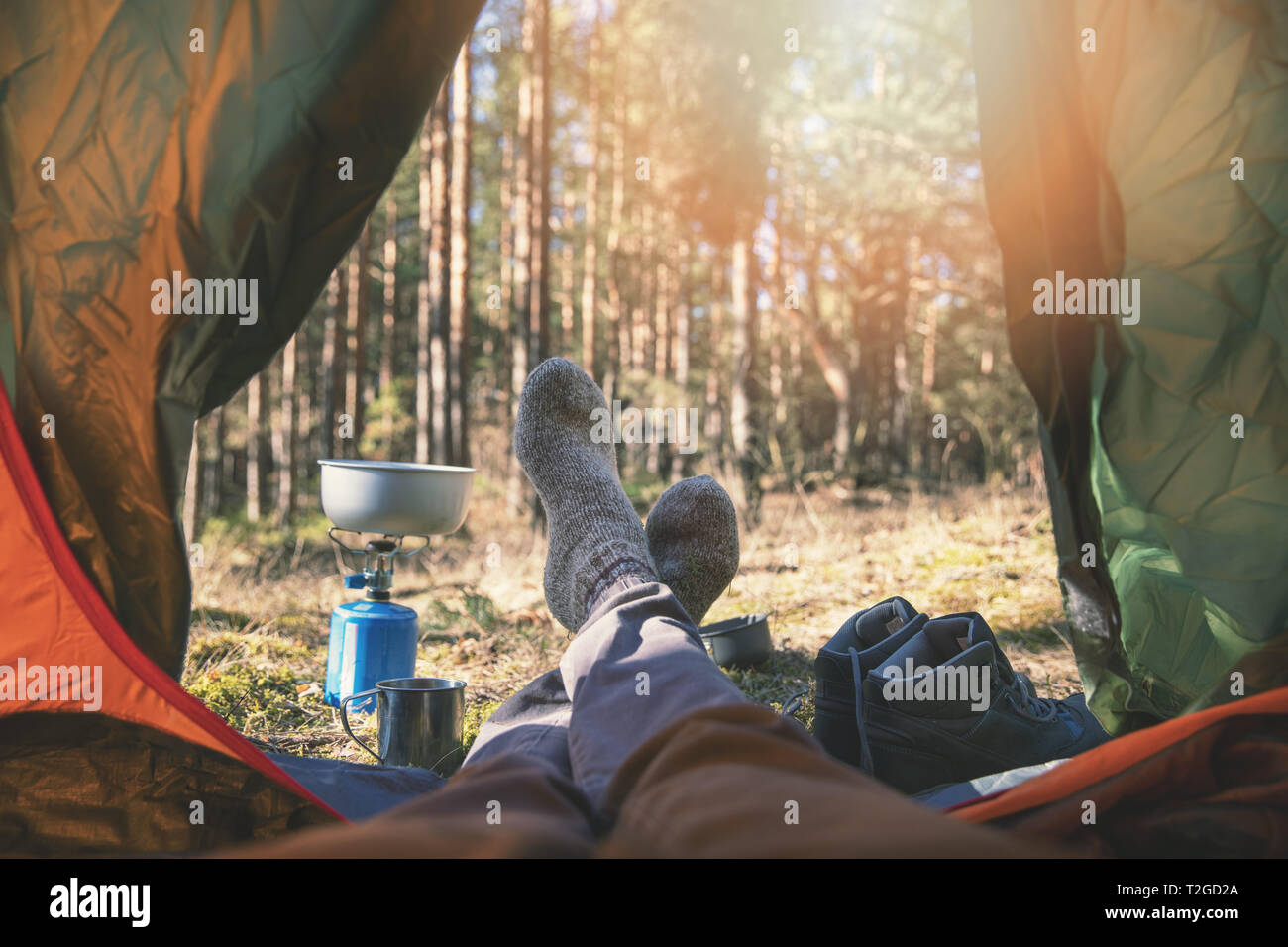 wanderlust outdoor camping - traveler feet out of the tent Stock Photo