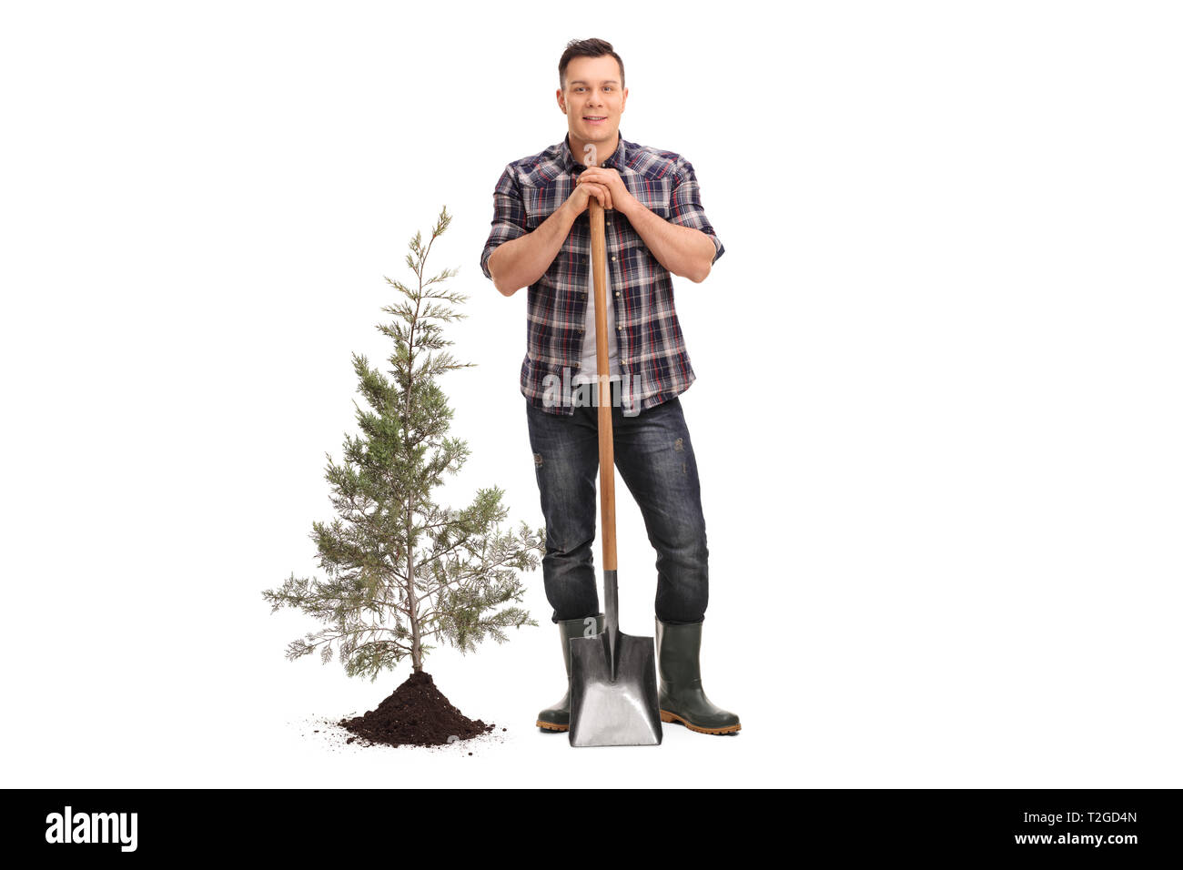 Full length portrait of a man posing with a shovel next to a planted ...