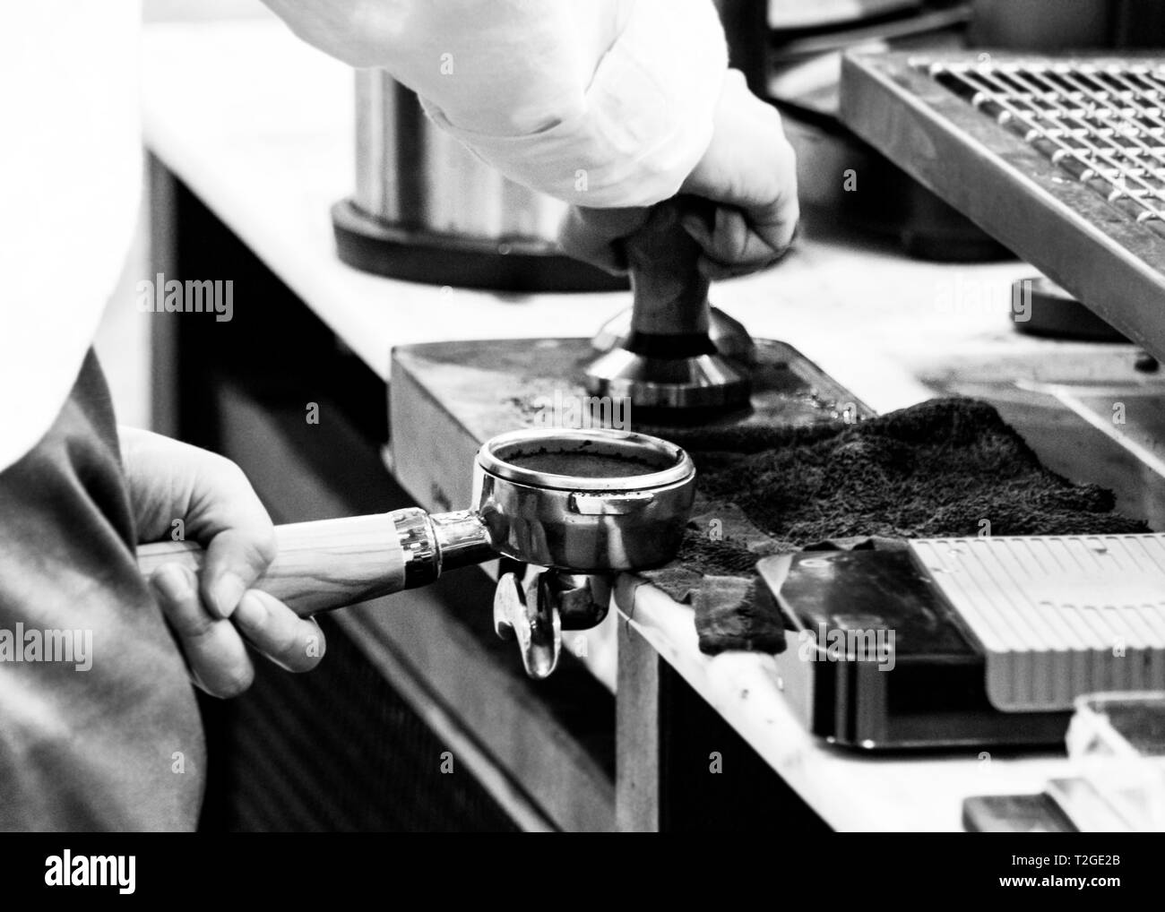 Barista working in a coffee shop, Close up of barista presses ground