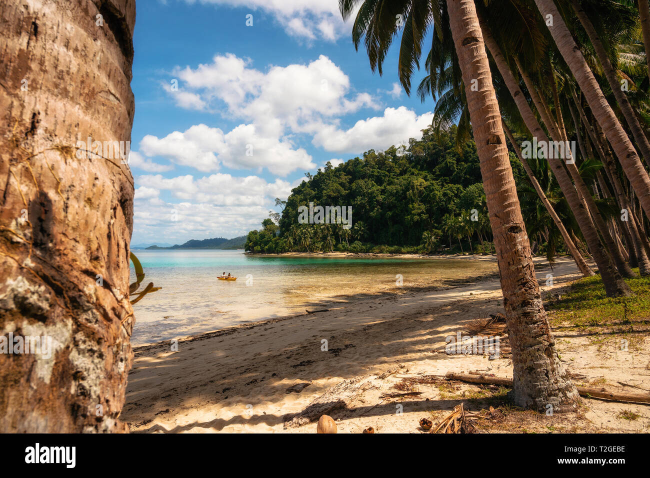 Two people go by kayak to uninhabited island. Young happy couple traveling on a rowboat. Recreational activities on the water in Philippines. Stock Photo