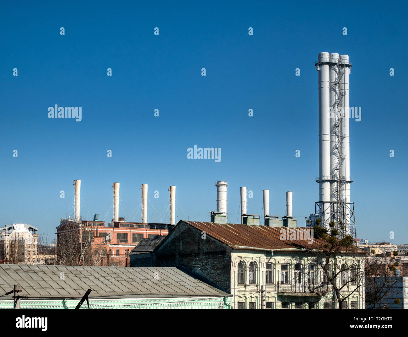 Tall factory pipes chimneys of light industry plant at industrial zone ...