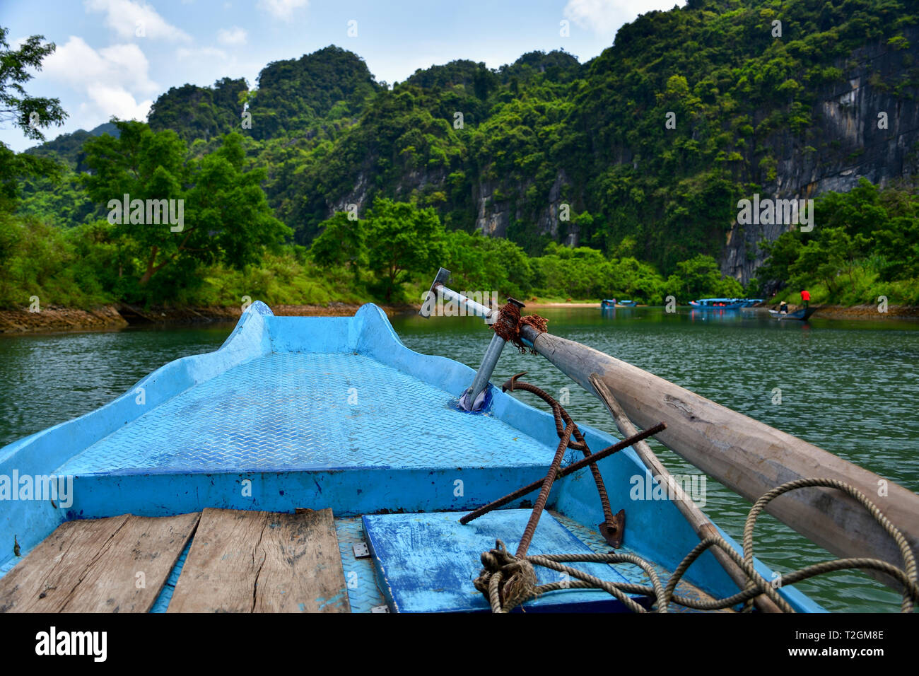 Boat ride to Phong Nha cave in Vietnam. Jungle covered limestone mountines of Phong Nha - Ke Bang National Park in the background. Stock Photo