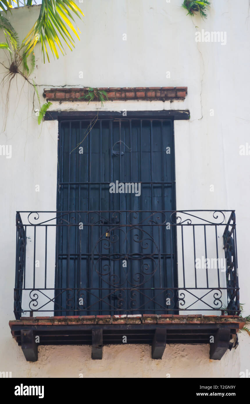 image of colonial balcony with black forged irons and tiles with white walls Stock Photo