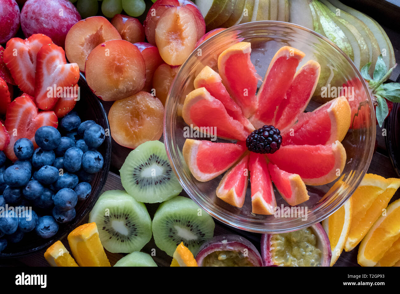 Platter of colourful fruit, sliced up, including grapefruit, kiwi