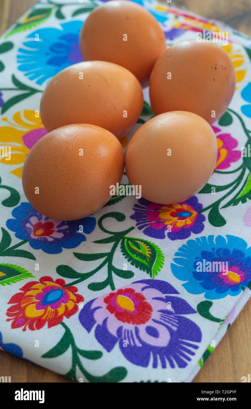 Eggs from organic farming from the village arranged on a colorful tablecloth in folk patterns Stock Photo
