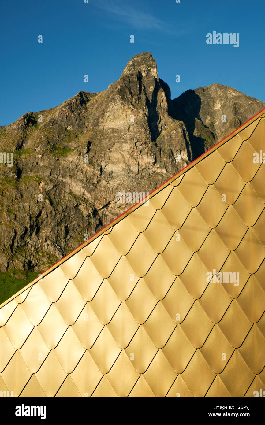 The triangular gold paneled rest room building and mountain at the beach of Ersfjordstranda in Senja, Troms, Norway - Architect: Tupelo Arkitektur Stock Photo
