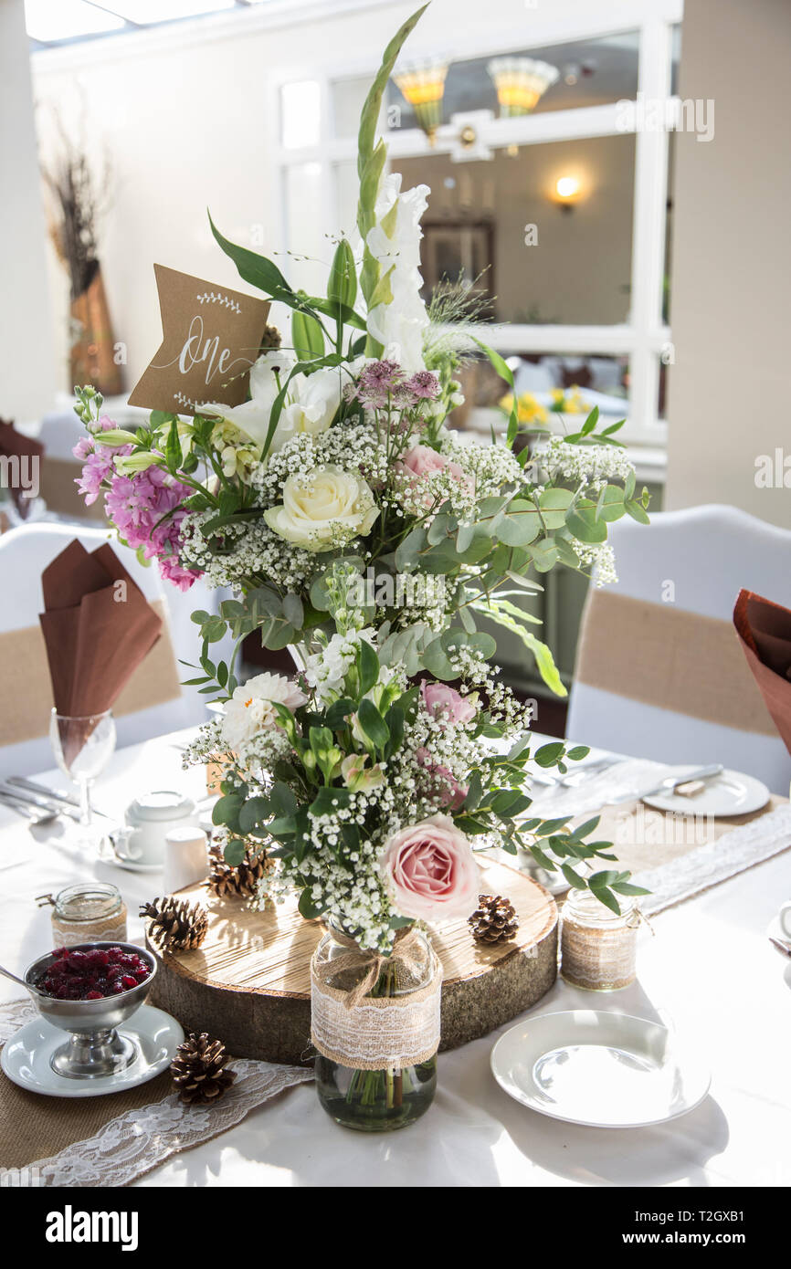 Floral wedding day decorations on tables at the wedding reception Stock