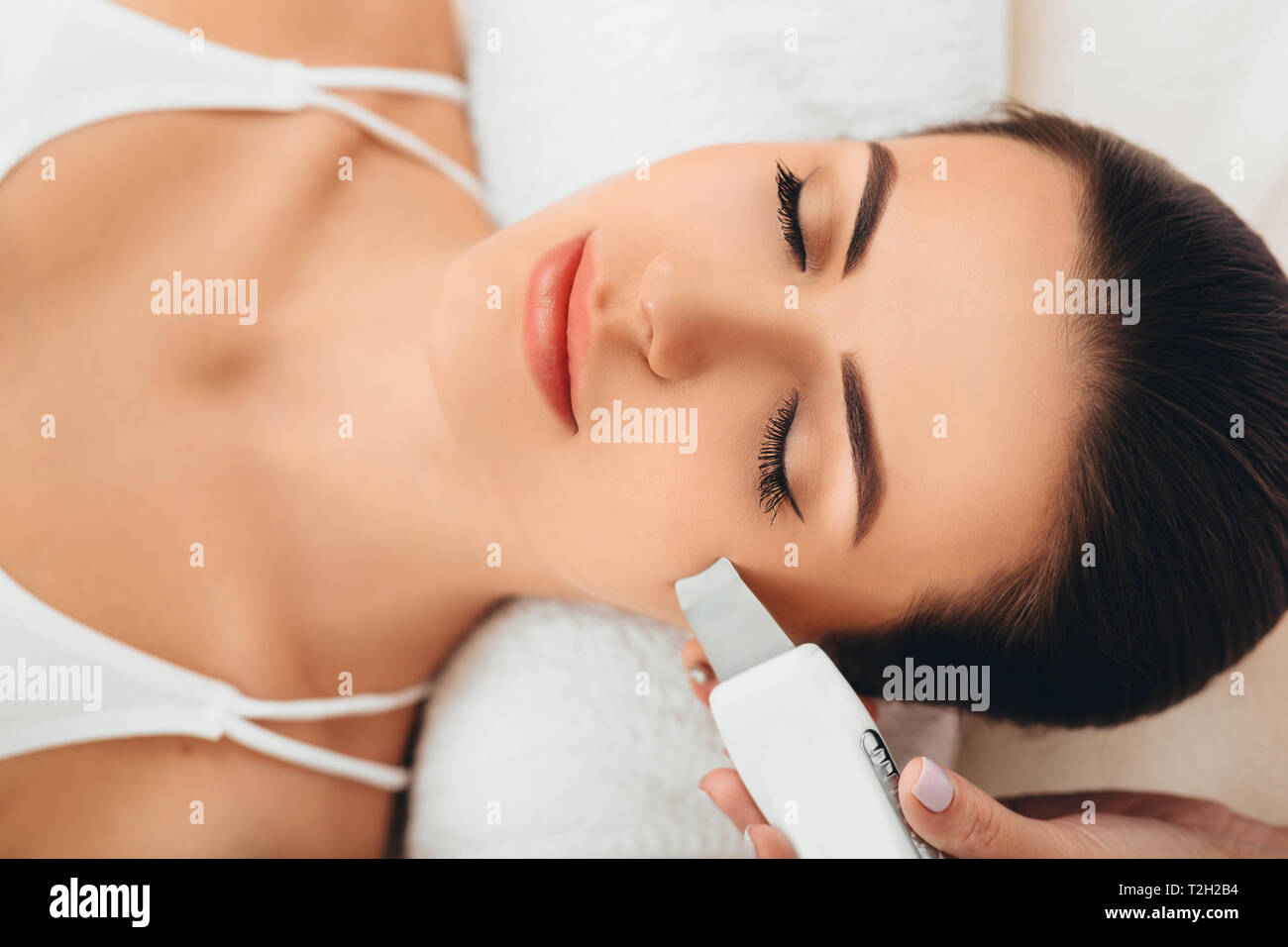 Beautiful woman receiving ultrasonic facial exfoliation at spa. Procedure clearing clogged pores, ultrasonic treatment for skin rejuvenation Stock Photo