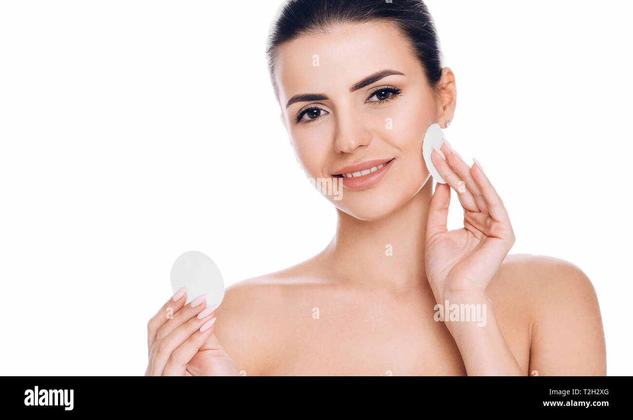 woman removing makeup from her face with facial cosmetic pad Stock Photo