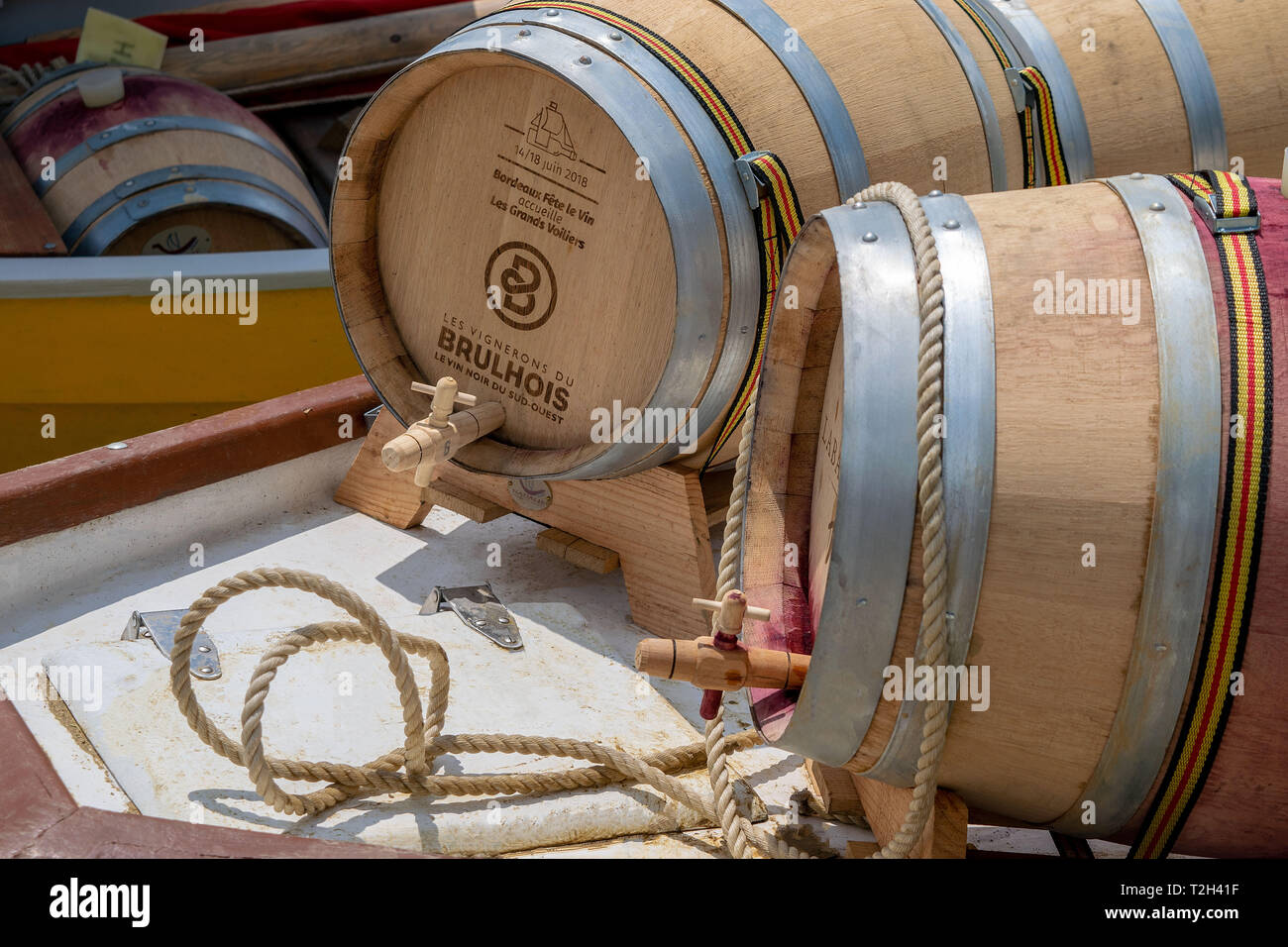 A photo of red wine barrels loaded on a barge for the journey down the river  to Bordeaux on a re-enactment of an old way of transporting the wine Stock Photo