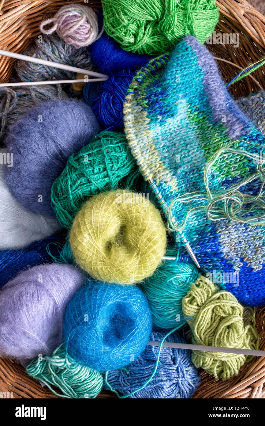 Balls of colourful wool in a knitting basket Stock Photo