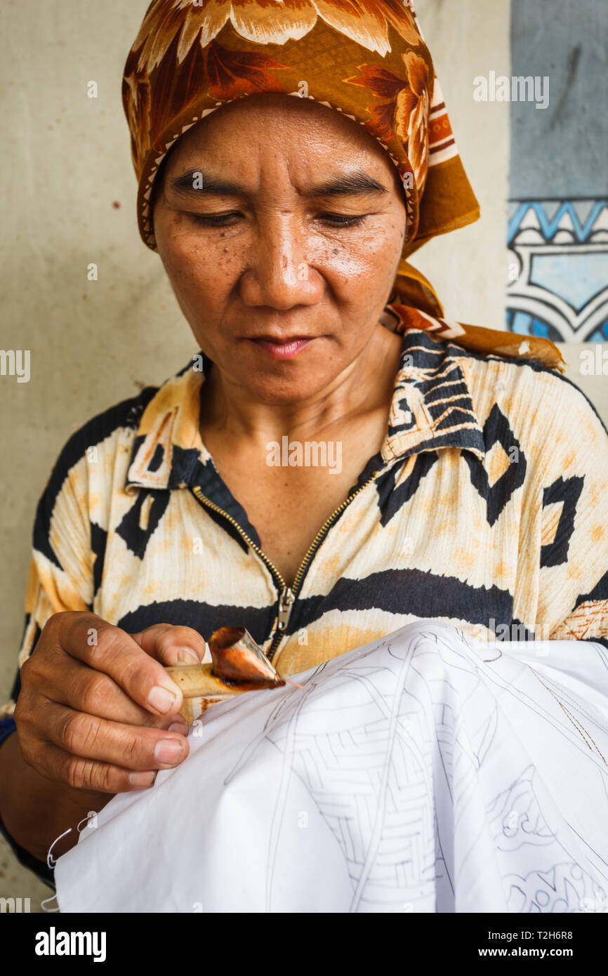 Portrait of a woman working on making a design on a handmade tablecloth Stock Photo
