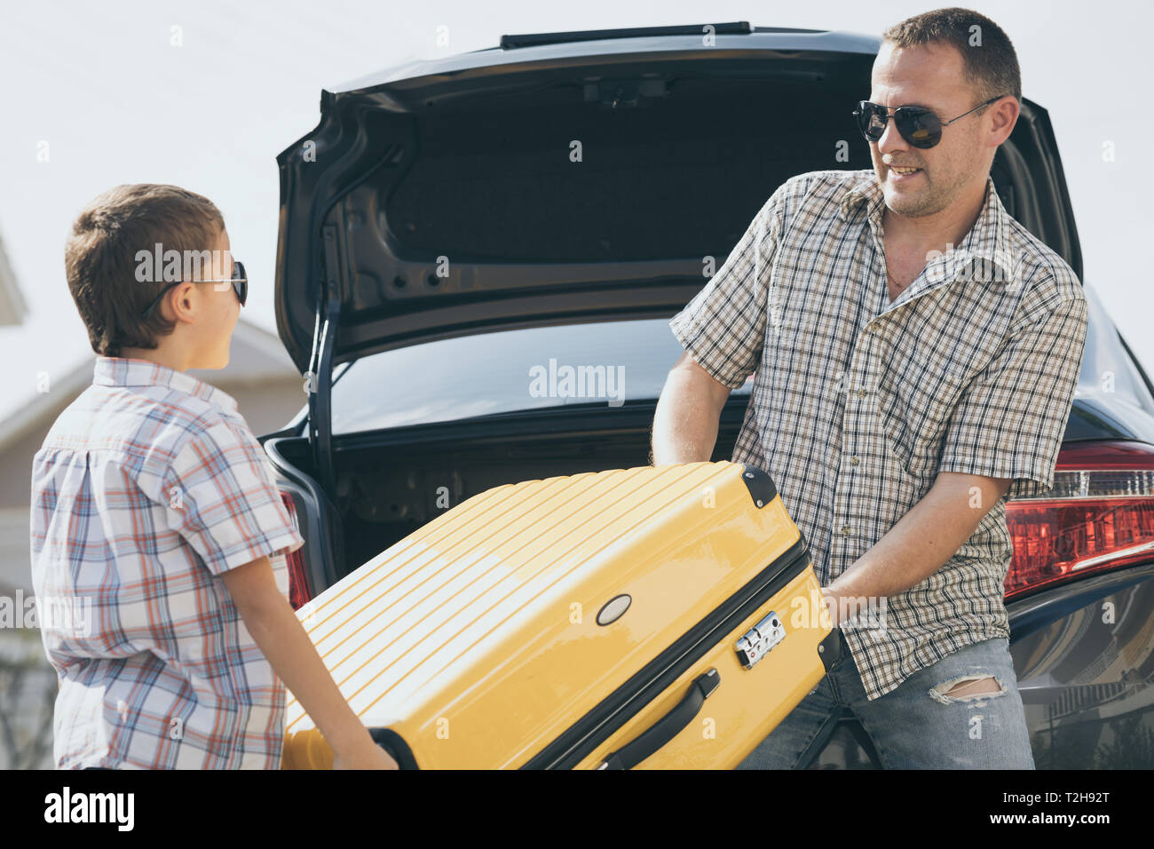 Happy father and son getting ready for road trip on a sunny day. Concept of friendly family. Stock Photo