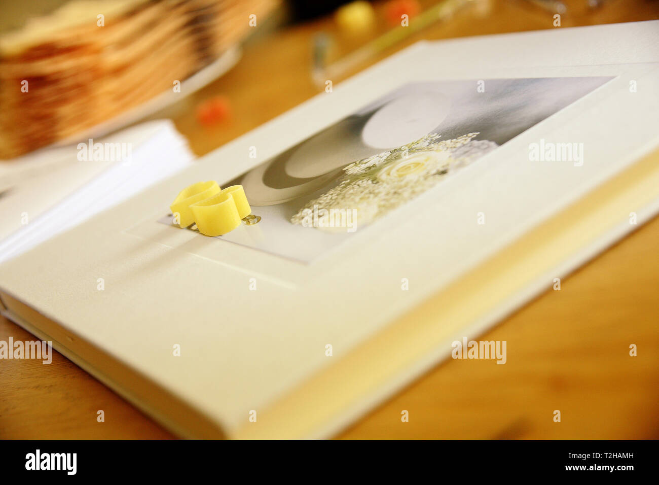 Two hearts formed from noodles lie on a wedding photo album. Stock Photo