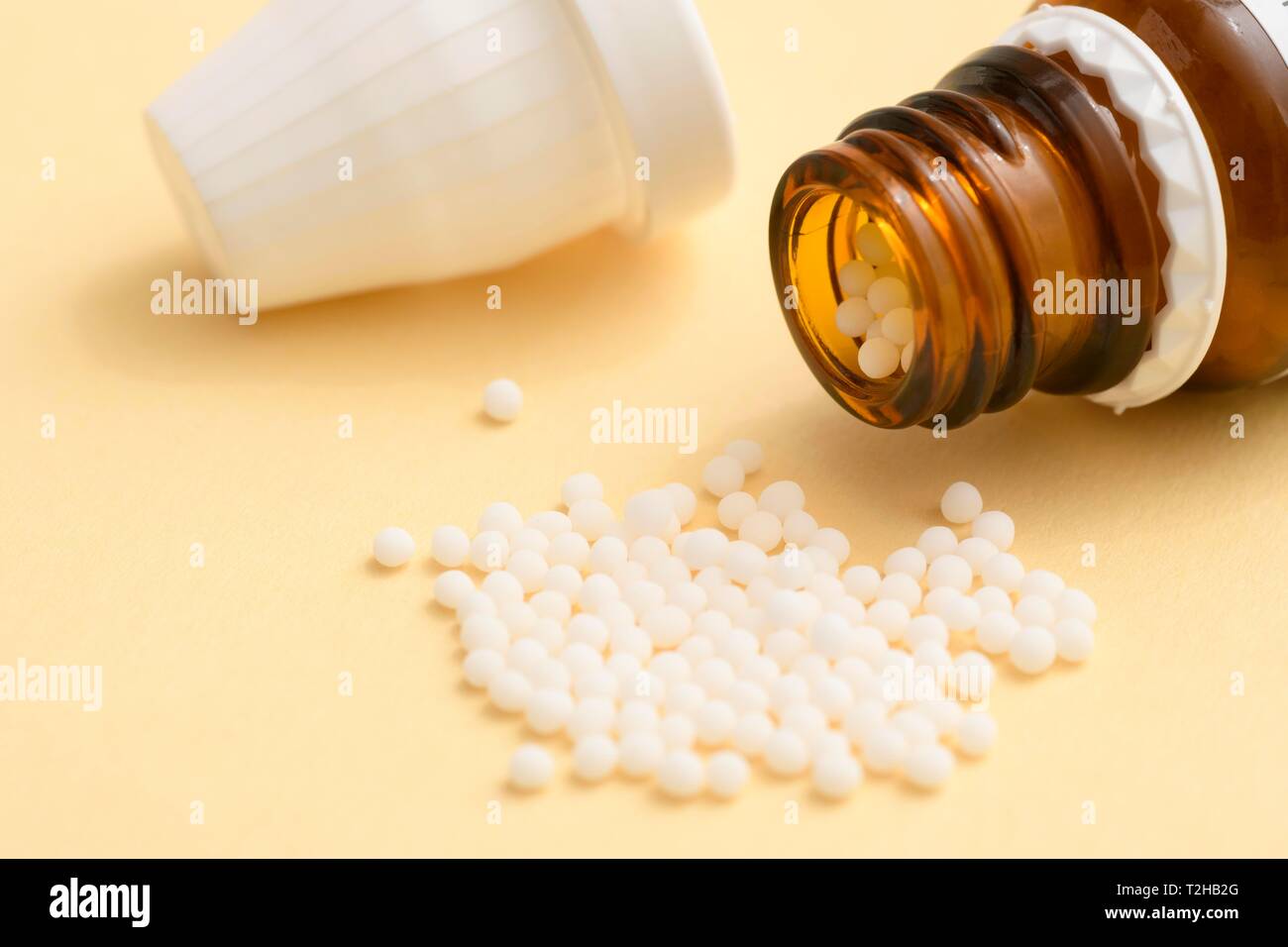 Globules in a pile with bottle, Homeopathy, Germany Stock Photo