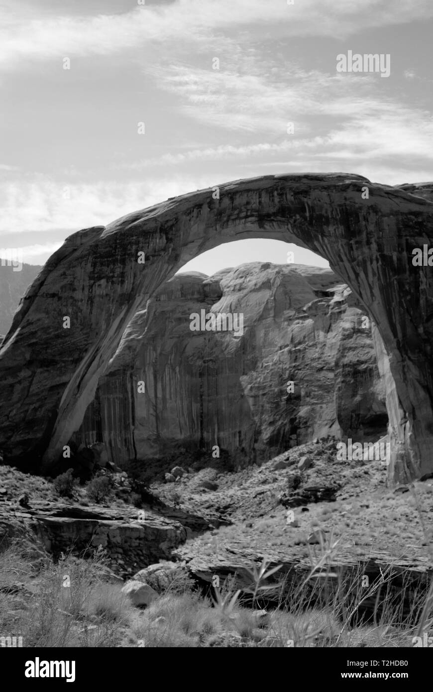 Rainbow arch view in black and white with cloudy sky. Stock Photo