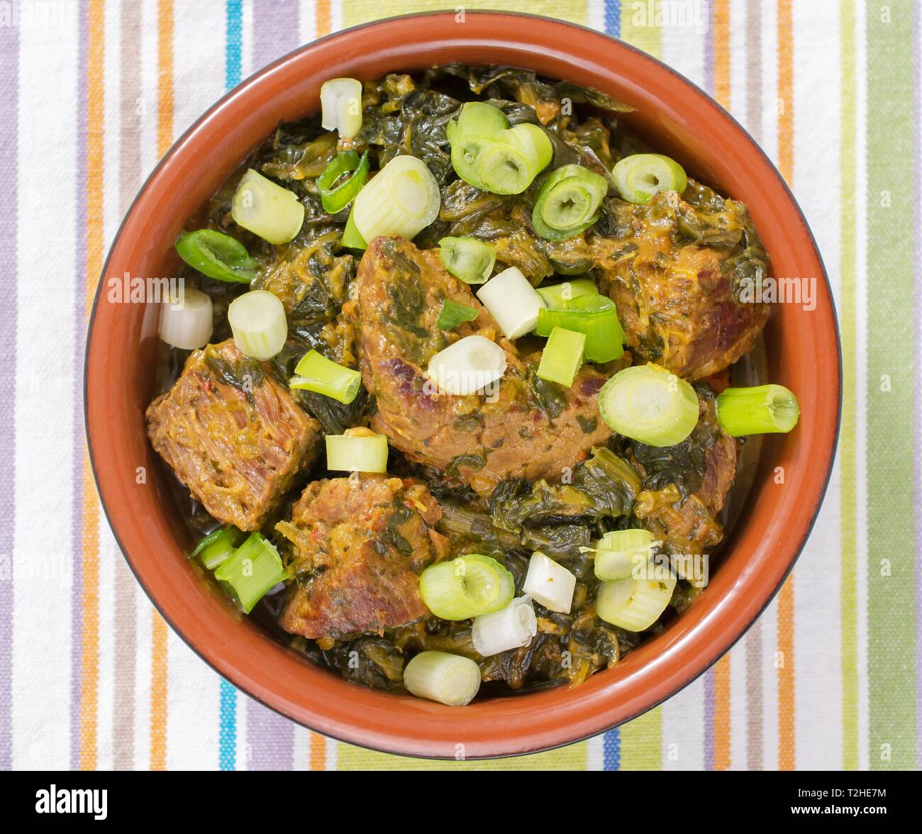 Beef with peanut and spinach in brown Kermaik bowl, dish from Mali, African cuisine, Mali Stock Photo
