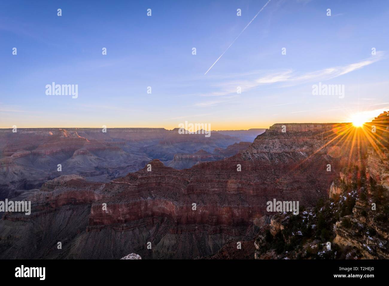 Gorge of the Grand Canyon at sunrise, Sun Star, View from Rim Walk, eroded rock landscape, South Rim, Grand Canyon National Park, Arizona, USA Stock Photo