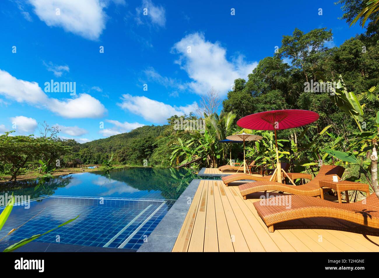 Swimming pool with sunbeds and umbrellas, Fearn Resort, Mae Hong Son, Thailand Stock Photo