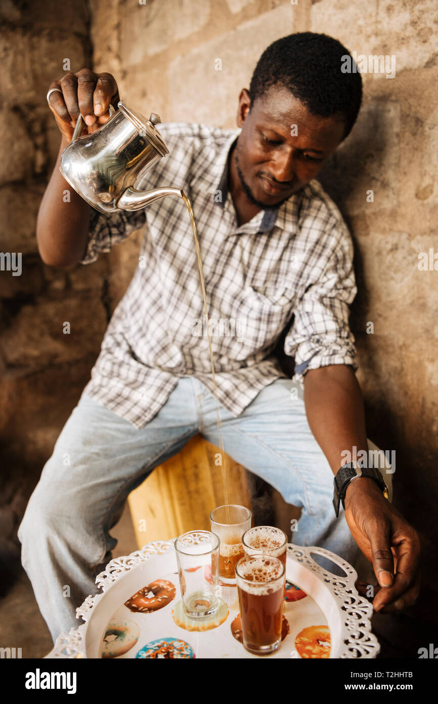 Man pouring traditional tea in Accra, Ghana, Africa Stock Photo