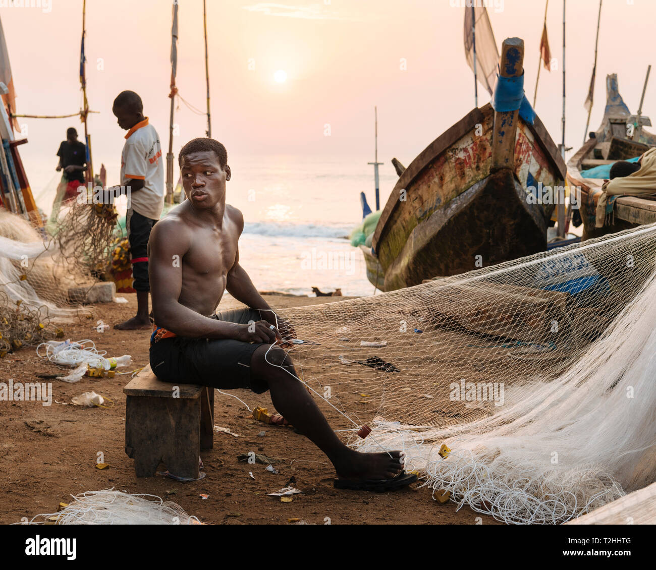 Fisherman fixing nets on beach in Cape Coast, Ghana Stock Photo