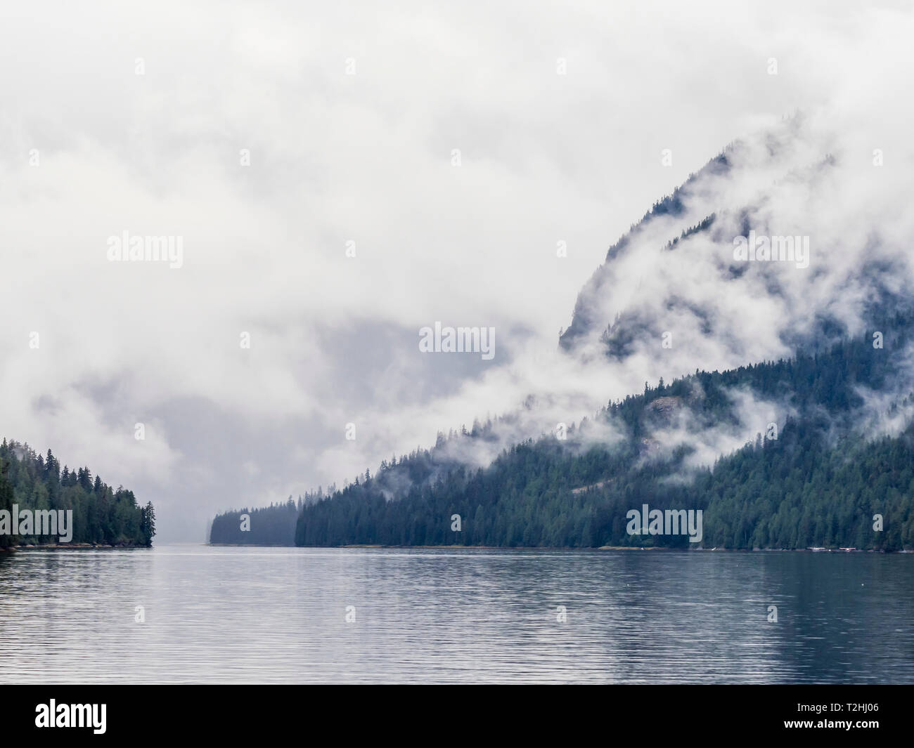 Low lying clouds shroud the mountain tops in Misty Fjords National Monument, Southeast Alaska, United States of America Stock Photo