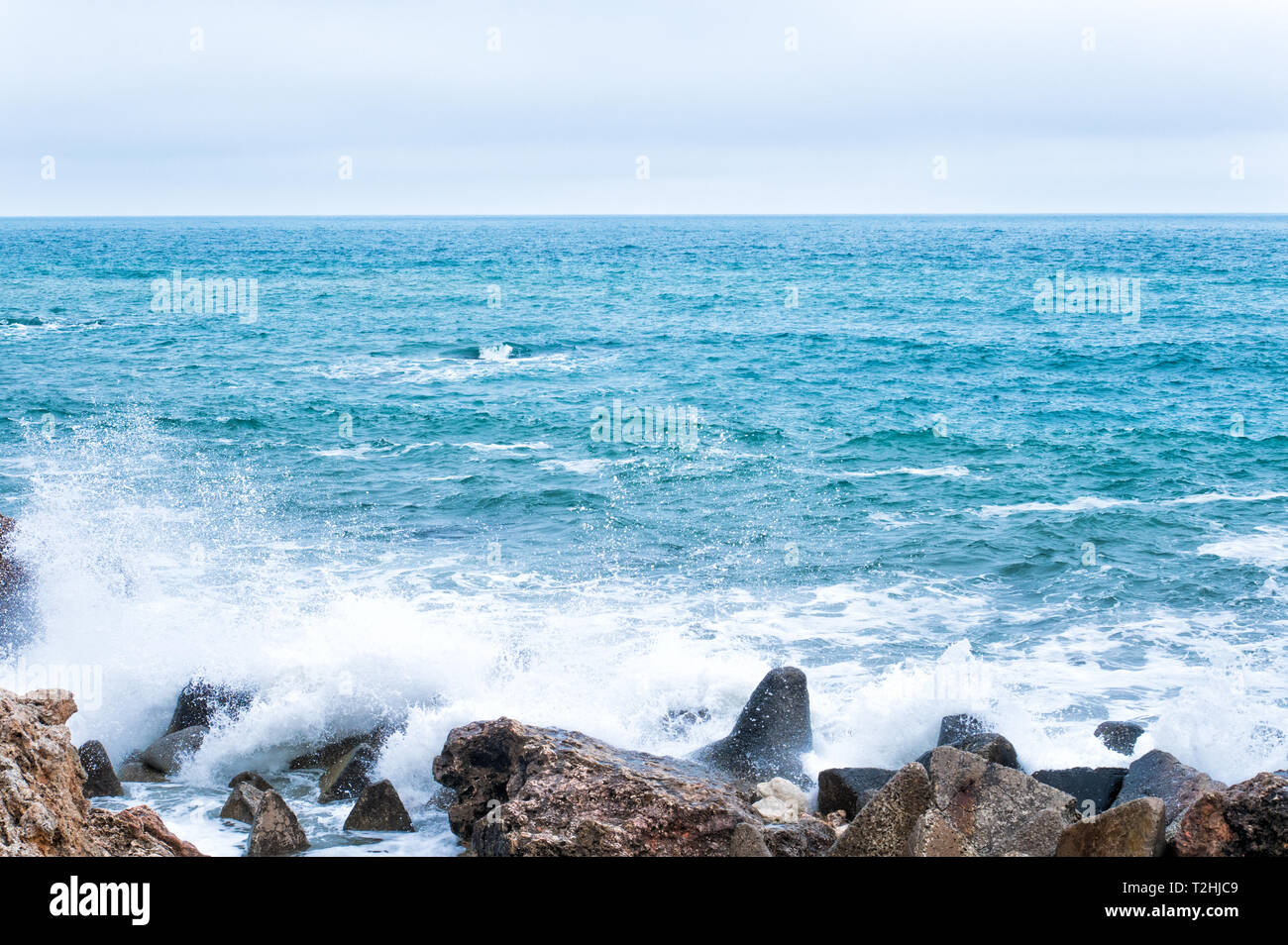 Nature background with waves break against the sea stony shore Stock Photo