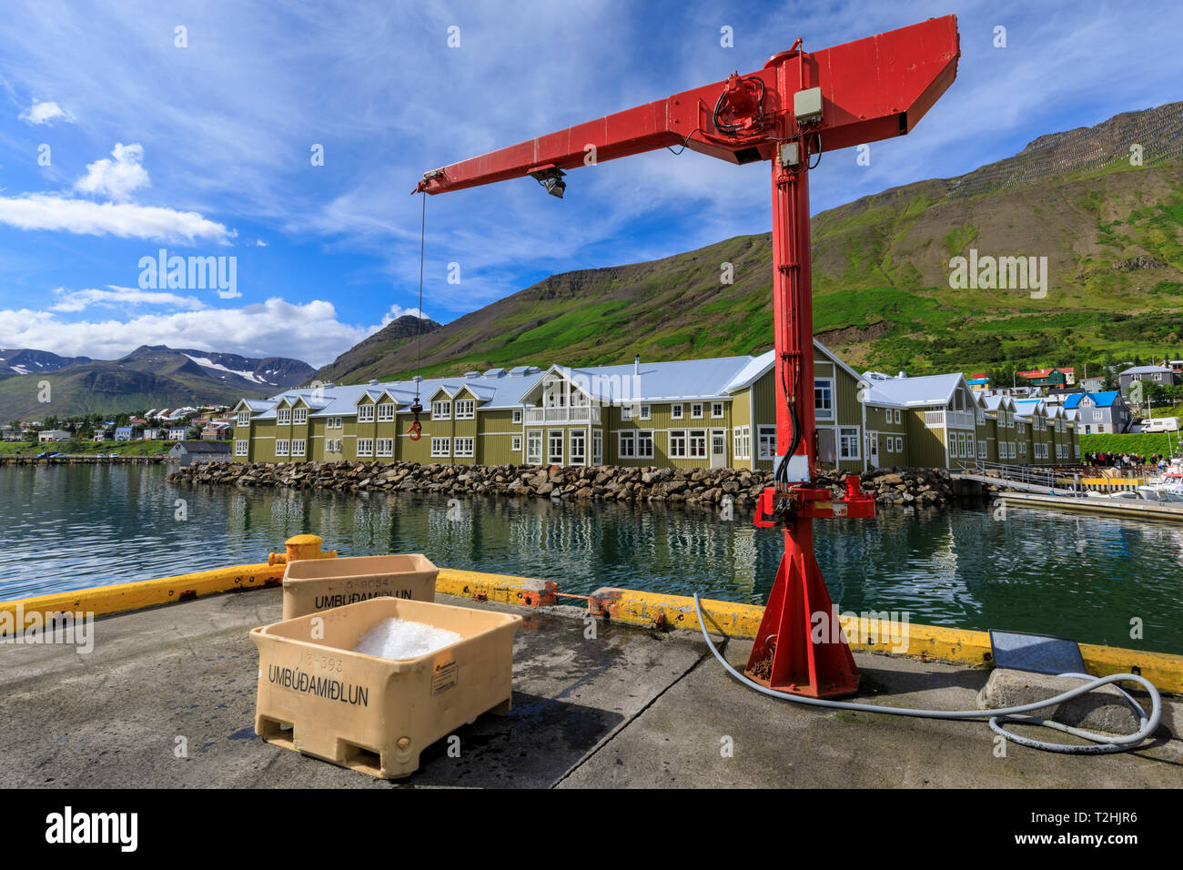 Fishing crates and equipment on quay, mountains and town, Siglufjordur, (Siglufjorour), stunning Summer weather, North Iceland, Europe Stock Photo