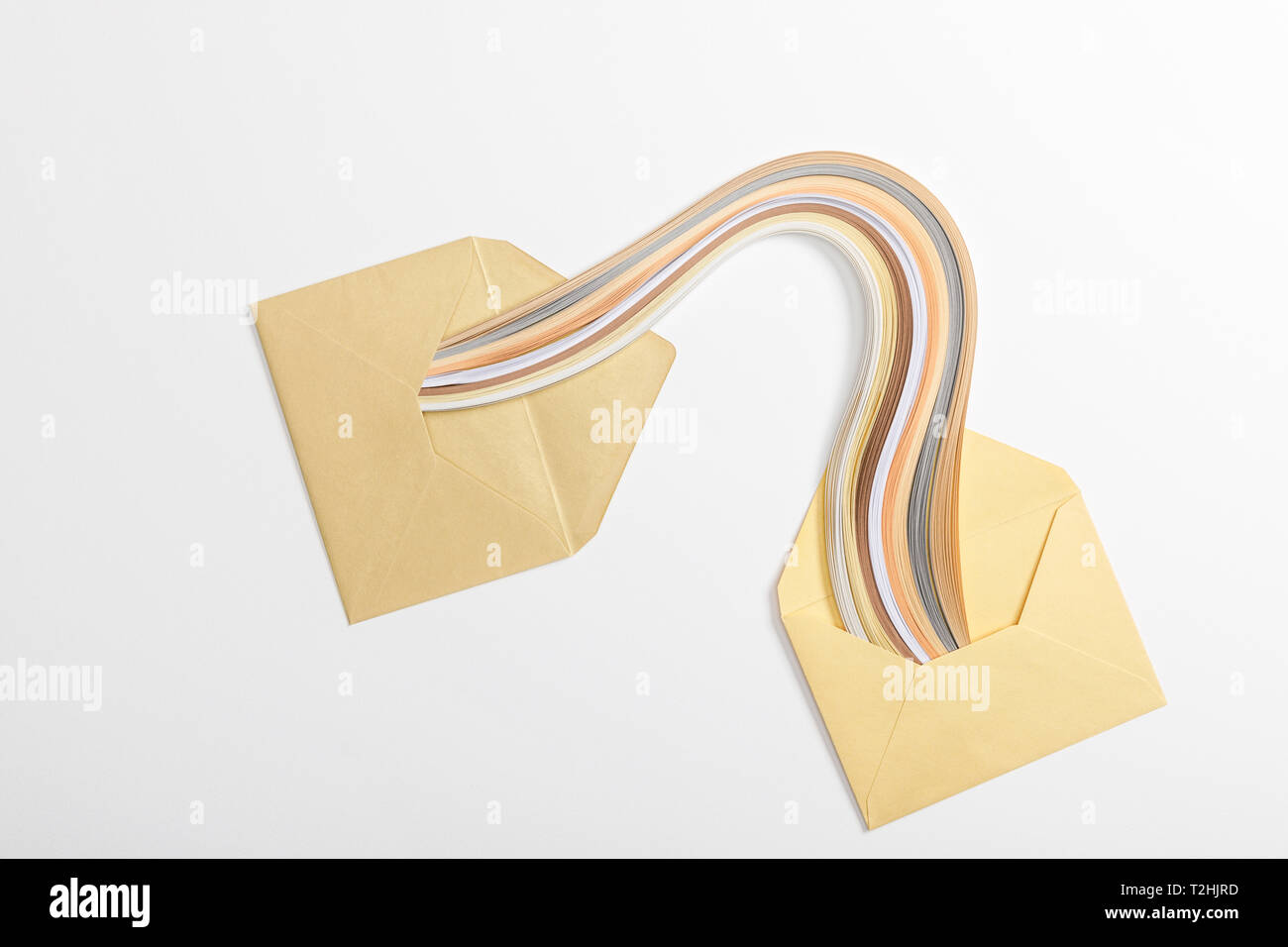 top view of yellow envelopes with multicolored rainbow on grey background Stock Photo