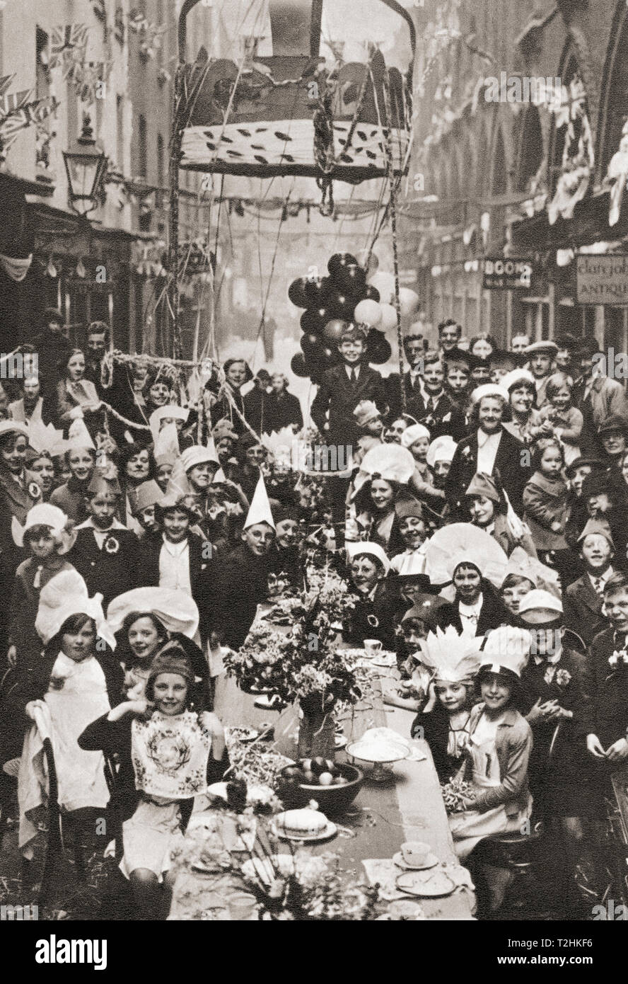 A typical London street tea party.  Children celebrate the Coronation of George VI and Queen Elizabeth in 1937.  From The Coronation in Pictures, published 1937. Stock Photo