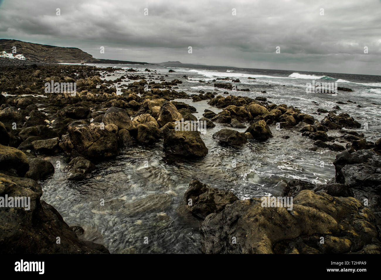 stony ocean shore at lanzarote island in the spring. grey color, no filters, real colors Stock Photo