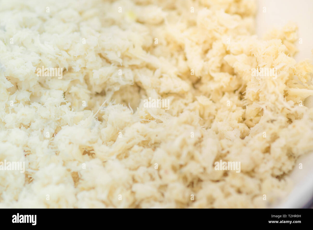 Grated horseradish root background close-up. Macro shot. Stock Photo