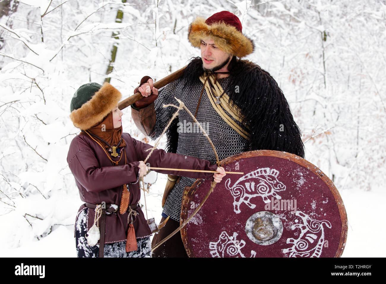 Viking warrior with chain mail leather spear walking in winter woods